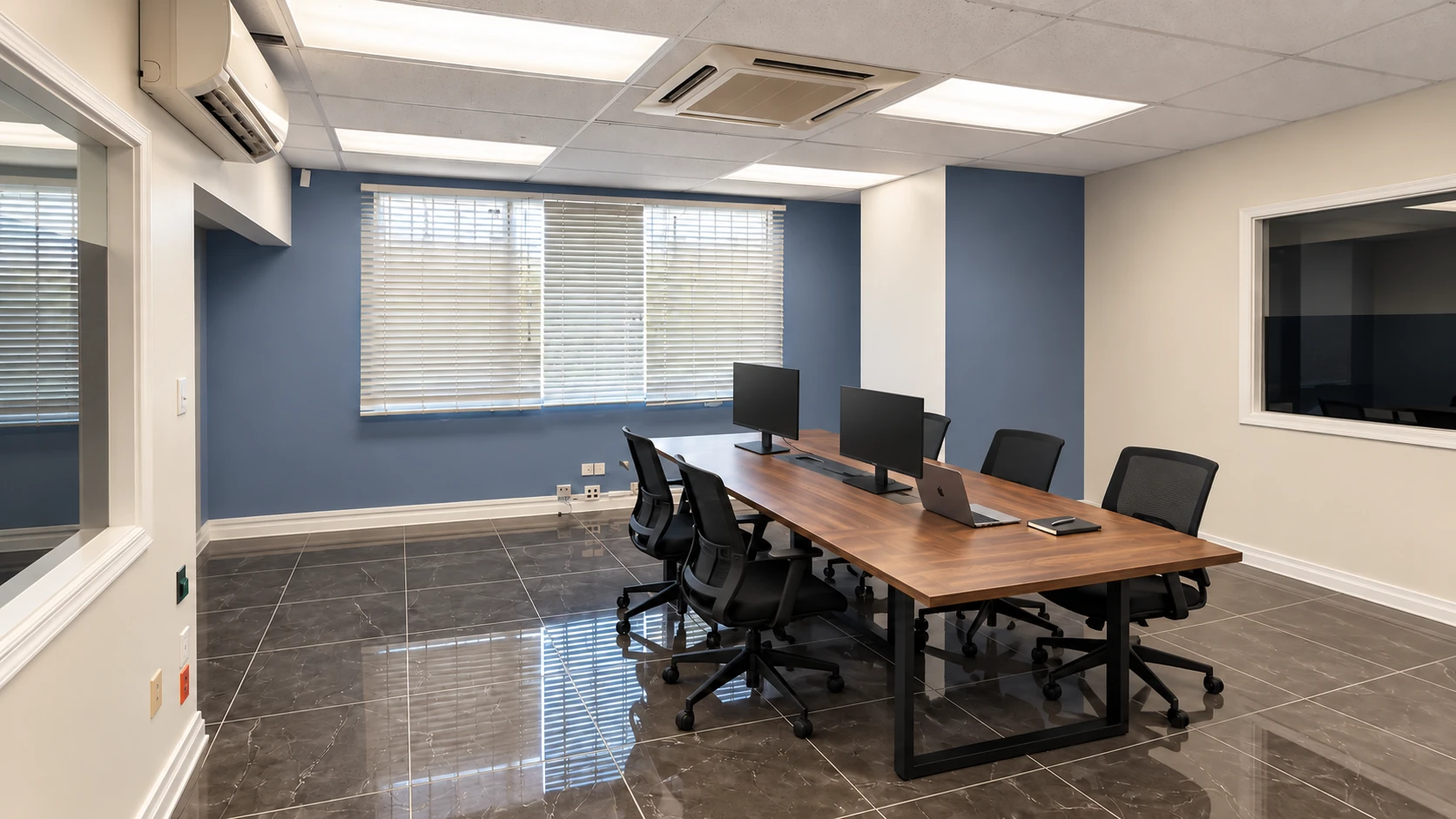 NEVI conference area with a walnut table, two monitors and office seating